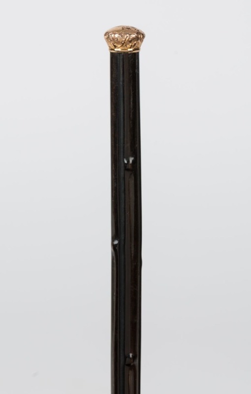 An antique walking cane with gold finished top on a baleen shaft with brass ferrule, 19th century, 86.5cm high