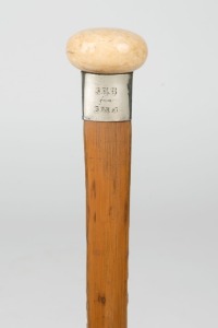 An antique walking stick with turned ivory handle, silver collar, cane shaft and brass ferrule, 19th century, 90cm high