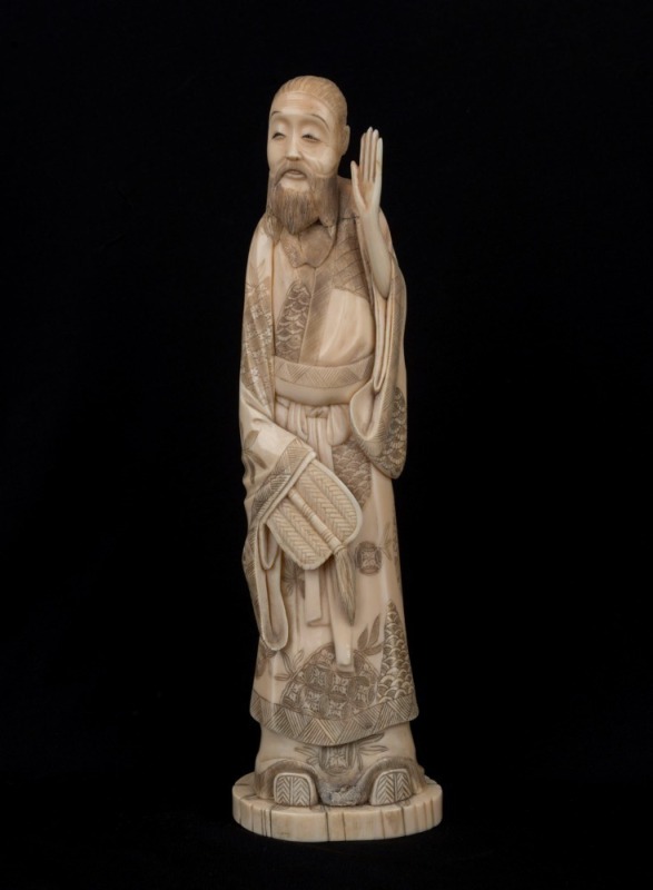 An antique Japanese marine ivory carved statue of a man, Meiji Period, 19th century, 25cm high