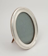 A sterling silver oval table picture frame, made in Birmingham, circa 1914, ​​​​​​​20.5cm high