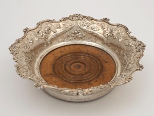 An antique American silver wine bottle coaster with turned wooden base, 19th century, stamped "STERLING", maker's marks rubbed, 6cm high, 21.5cm wide