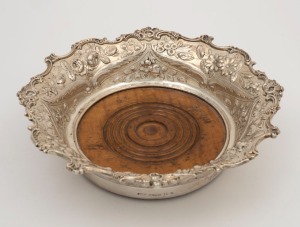 An antique American silver wine bottle coaster with turned wooden base, 19th century, stamped "STERLING", maker's marks rubbed, ​​​​​​​6cm high, 21.5cm wide