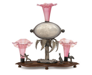 An Australiana centrepiece display, carved emu egg in silver plated ferntree mount, adorned with Aboriginal figure, kangaroo, emu and ruby glass epergne trumpets, late 19th century, 31cm high, 31cm wide