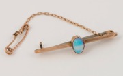 An antique Australian&nbsp;9ct rose gold bar brooch, set with a solid polished opal, late 19th century, ​​​​​​​4.5cm wide, 3.9 grams total