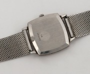 LONGINES manual wristwatch in square stainless steel case with silver dial, baton numerals and stainless steel mesh band, circa 1960. 3.1cm wide including crown - 3