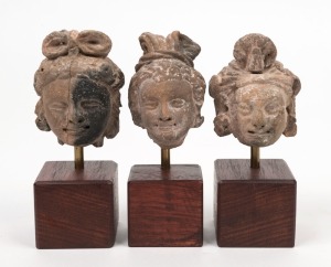 A group of three Gandharan terracotta heads of a Bodhisattva, circa 3rd century A.D., approximately 7cm high each (excluding stands)
