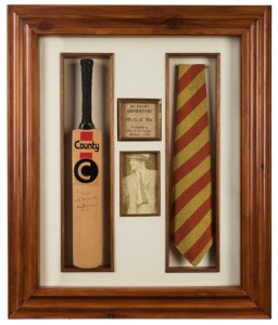 An attractively framed presentation featuring a mini-bat signed and dedicated by Don Bradman, and an M.C.C. tie presented by Bradman, overall 60.5 x 50.5cm. Mr & Mrs Cooke visited Bradman at his home in Adelaide on 9th September 1988. He presented them wi