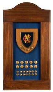 MARYLEBONE CRICKET CLUB: A framed display featuring the club plaque and a collection of ten large gilt blazer buttons and fourteen small gilt blazer buttons. 61 x 33cm overall.