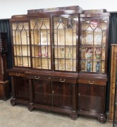 A Regency style English mahogany four door bookcase with break-front and top, astragal glazed doors and reeded columns, 19th century, 247cm high, 254cm wide, 59cm deep