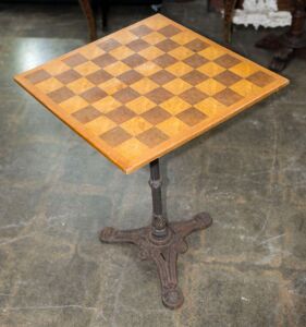 A games top cafe table with cast iron base, 71cm high, 53cm wide, 53cm deep