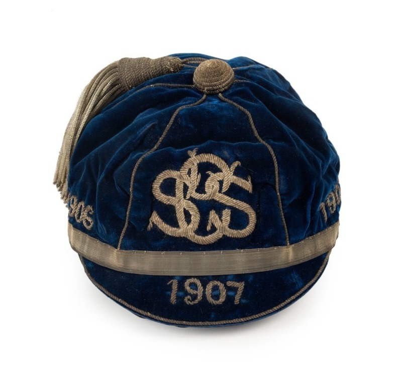 A deep blue velvet honour cap with silver metallic tassel and band around lower edge; silver metal thread "1906 SLSC 1907" applied to three front panels and "1907" also to peak; maker's label for "Farmer & Company Limited, Sydney" to the inner peak. Super