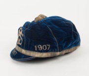 A deep blue velvet honour cap with silver metallic tassel and band around lower edge; silver metal thread "1906 SLSC 1907" applied to three front panels and "1907" also to peak; maker's label for "Farmer & Company Limited, Sydney" to the inner peak. Super - 3