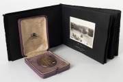 1930 BRITISH EMPIRE GAMES, HAMILTON, CANADA, a bronze and enamel participation medal in the maker's presentation box (Klein & Binkley, Hamilton, Can.); the oval shaped medal 39 x 50cm. Accompanied by a small annotated photograph album "To E.J. Holt, Souve - 2