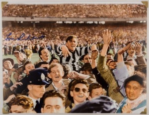 COLLINGWOOD: LOU RICHARDS original signature on wonderful reproduction photograph of him being carried off the ground after the 1953 Premiership game, overall 25.5 x 33cm.