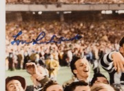 COLLINGWOOD: LOU RICHARDS original signature on wonderful reproduction photograph of him being carried off the ground after the 1953 Premiership game, overall 25.5 x 33cm. - 2