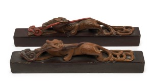 A pair of antique Chinese carved wood and lacquer scholar's scroll weights, Qing Dynasty, 19th century, with remains of Sotheby's label, 21.5cm long,