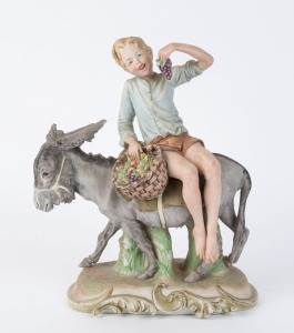 An Italian porcelain statue of a boy on a donkey eating grapes, mid 20th century, 33cm high