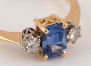 An antique 18ct yellow gold ring, set with an emerald cut Ceylonese sapphire, flanked by brilliant cut white diamonds, early 20th century, ​​​​​​​2.9 grams total - 2