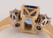 An antique 18ct yellow gold ring, set with an emerald cut Ceylonese sapphire, flanked by brilliant cut white diamonds, early 20th century, ​​​​​​​2.9 grams total - 3