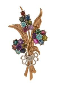 A vintage English floral brooch adorned with multi-coloured gemstones including diamonds, topaz, tourmaline, amethyst and various sapphires, all set in 9ct yellow gold and platinum, made in Birmingham, 1950, 5.5cm wide, 11.8 grams