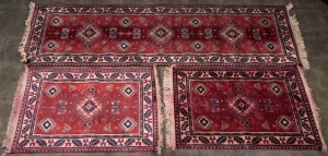 Three red patterned rugs, the largest 121cm long
