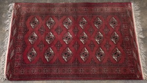 A Turkoman Persian hand-knotted wool rug red ground, 142 x 100cm