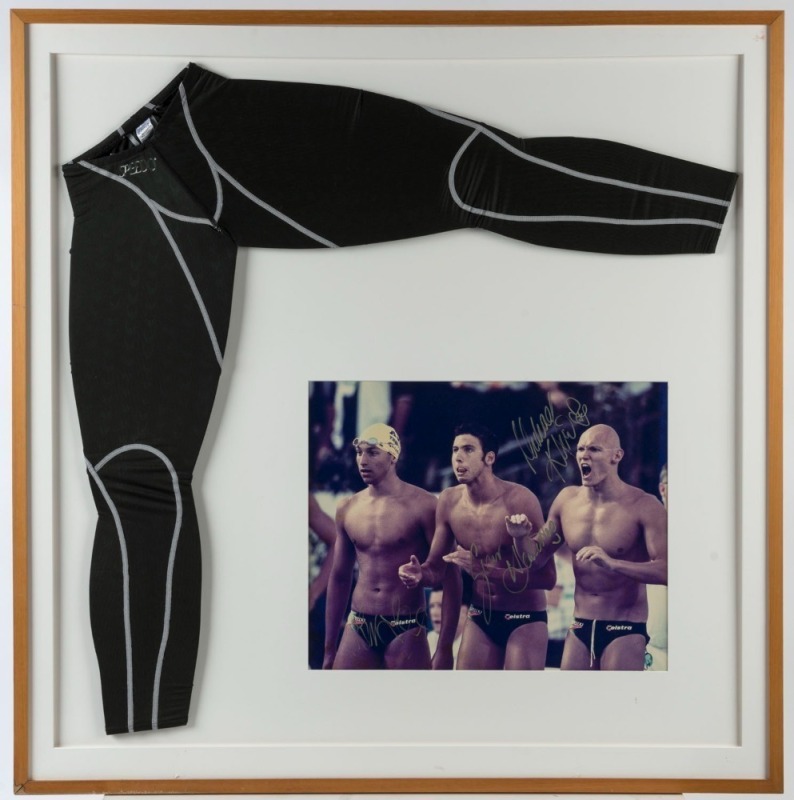 2000 SUMMER OLYMPICS - SYDNEY: Large photograph signed by Australian champion swimmers Ian Thorpe, Grant Hackett and Michael Klim. Mounted and framed together with a pair of Speedo leggings. Overall 106 x 105cm