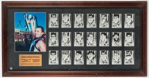 COLLINGWOOD FOOTBALL CLUB: 1990 Premiership display featuring a signed photograph of Tony Shaw holding aloft the Premiership Cup, framed together with a set of 21 caricature cards of Collingwood players. Overall 47 x 91cm