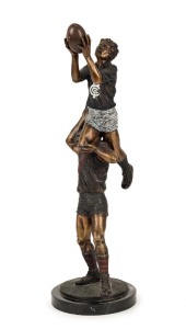 An impressive bronze statue on a black marble base, depicting a Carlton player taking a "screamer" over the shoulder of an Essendon player; overall 55cm high.