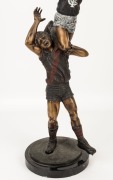 An impressive bronze statue on a black marble base, depicting a Carlton player taking a "screamer" over the shoulder of an Essendon player; overall 55cm high. - 3