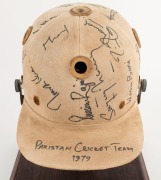 1979 PAKISTAN CRICKET TEAM: Match worn batting helmet signed by 15 members of the Pakistan touring party, attractively displayed on a custom built timber base. Accompanied by "The Pakistan Book of Test Cricket 1952-53 - 1982" by Abid and Masood as well as - 2