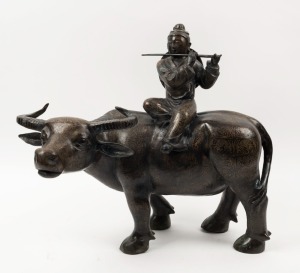 A Chinese bronze statue of a flute player sitting on a bull, 20th century, ​​​​​​​45cm high, 51cm long