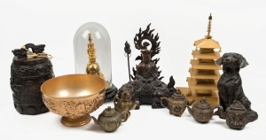 Gilded pagoda ornaments (one in glass dome), gilt finished dragon bowl, five assorted bronze teapots, a dog statue, a bronze temple, and a seated bronze statue, mixed vintages, (11 items), the largest 38cm high