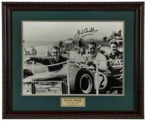 JACK BRABHAM (1926 - 2014), the three-times Formula One World Champion, signature on large format photograph of Brabham holding his winner's cup; attractively framed & glazed, overall 46 x 55.5cm. With CofA affixed verso.