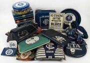 A collection of Carlton cushions or pillows, ties, a plastic carry bag, a night cap, a money box, a small football, various lanyards, a roll of Footy ribbon, some ashtrays, trays, coasters, and souvenir biscuit tins. (40+ items).