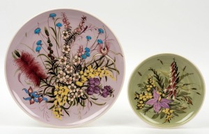 GUY BOYD two hand-painted pottery wall plaques with wildflower decoration on pink and green grounds, incised "Guy Boyd, Australia", 24cm and 15cm diameter