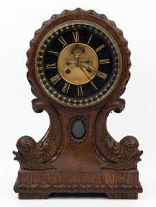 An antique French mantle clock in oak case with finely carved dolphin decoration, eight day time and strike movement with open escapement and Roman numerals, 19th century, 37cm high