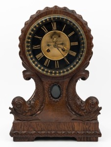 An antique French mantle clock in oak case with finely carved dolphin decoration, eight day time and strike movement with open escapement and Roman numerals, 19th century, ​​​​​​​37cm high