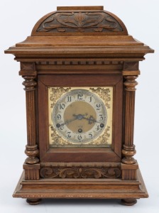 An antique German table clock in carved walnut case, three train chiming movement with Arabic numerals, early 20th century, 45cm high