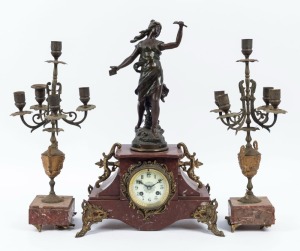An antique French figural three piece clock set, rouge marble with gilt metal mounts and spelter statuette, eight day time and strike movement with Arabic numerals, 19th century, Note: Garnitures in poor condition. The clock 49cm high