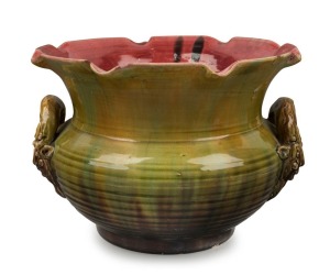 V.A.P. (VICTORIA ART POTTERY) rare pottery jardiniere by WILLIAM FERRY with face mask gargoyle handles, glazed in green and yellow with pink interior, late 19th century, impressed mark "VICTORIA ART POTTERY, W.F.", 19.5cm high, 29cm wide