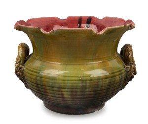 V.A.P. (VICTORIA ART POTTERY) rare pottery jardiniere by WILLIAM FERRY with face mask gargoyle handles, glazed in green and yellow with pink interior, late 19th century, impressed mark "VICTORIA ART POTTERY, W.F.",  19.5cm high, 29cm wide