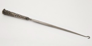 An antique silver boot hook with repousse decoration, 33.5cm long