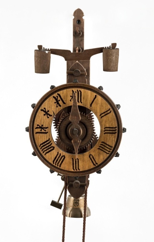 A reproduction wall clock in the 15th century style, with wooden wheels and frame, weight driven movement with Foliot balance, 20th century, 39cm high