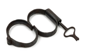 "Plug 8"convict handcuffs with original plug and fluted key, 19th century, 13.5cm wide