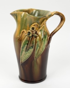 REMUED pottery vase with applied gumnuts and leaves, glazed in green and brown, incised "Remued, Hand Made, 133M", 24cm high