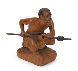 A carved statue of a crouching Maori warrior with taiaha and full Tā moko, 20th century, 20.1cm high