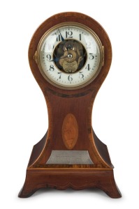 MANLY INTEREST: EUREKA CLOCK Co. antique English mantle clock in mahogany balloon case with marquetry inlay in the Sheraton manner, three ball bearing movement with electric coil and balance wheel, white glass chapter ring with Arabic numerals with exposed balance wheel, early 20th century. Bearing silver presentation plaque inscribed "Presented To H. AUSTIN Esq. By The Members Of The MANLY AMATEUR SWIMMING CLUB On The Eve Of His Retirement Of The Position Of Honourary Secretary After 10 Years