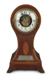 MANLY INTEREST: EUREKA CLOCK Co. antique English mantle clock in mahogany balloon case with marquetry inlay in the Sheraton manner, three ball bearing movement with electric coil and balance wheel, white glass chapter ring with Arabic numerals with expose