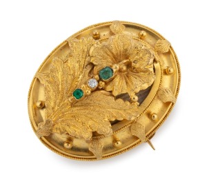 A Colonial 15ct yellow gold locket front leaf brooch, set with two emeralds and a diamond, reverse with window back, circa 1870, 4cm high, 10.9 grams total